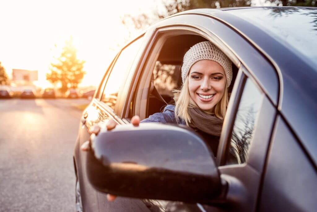 A person looking into the wing-mirror of their dual control car