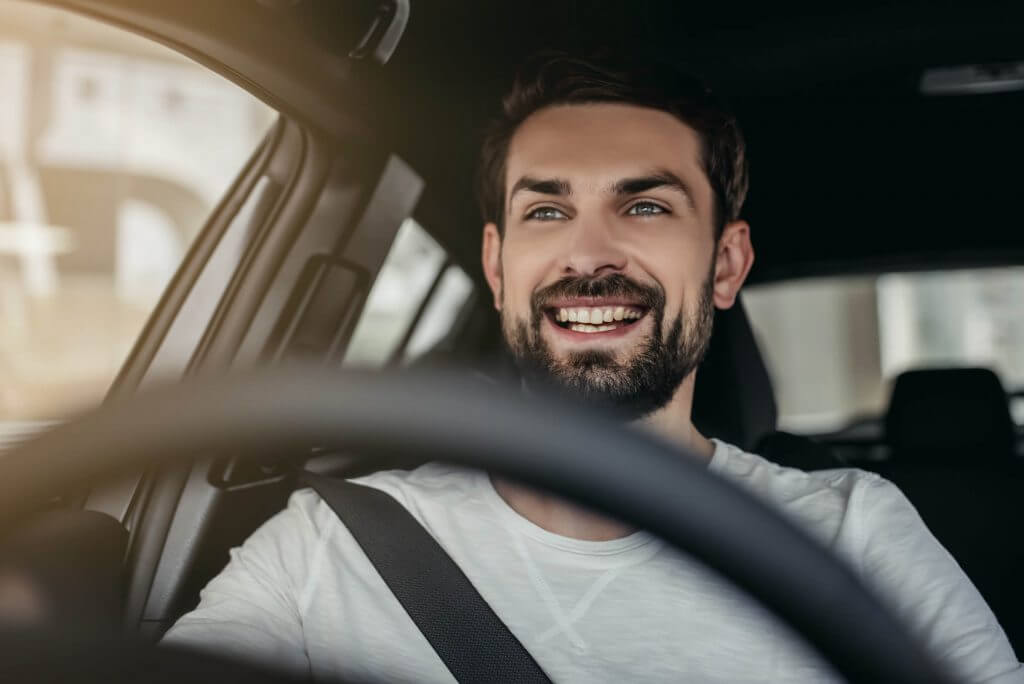 A person smiling whilst driving a dual control car